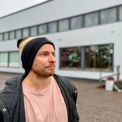 Joni Rönneberg utomhus framför byggnad. 