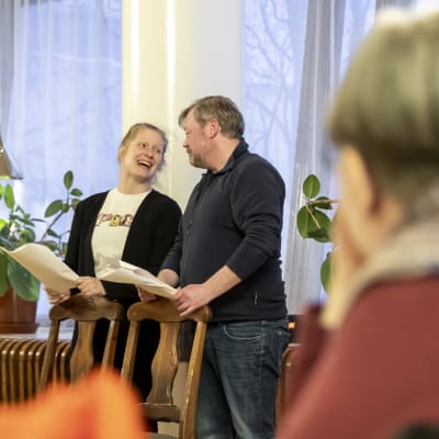 Johanna Virsunen ja Olli Halttu harjoittelevat menuteatterin esitystä. Näyttelijät hymyilevät toisilleen.