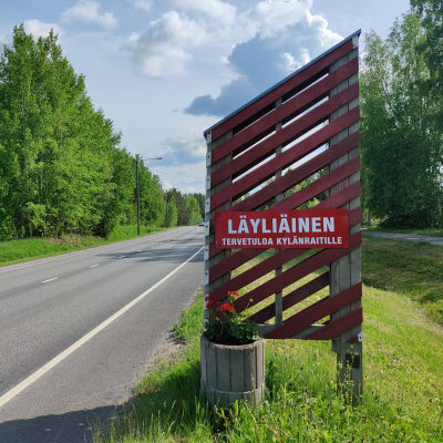 Tienvarsikyltti, jossa toivotetaan tervetulleeksi Läyliäisten kylään.