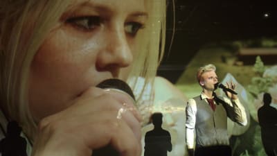 Iida Kuningas på stor skärm, Oskar Pöysti på scenen.