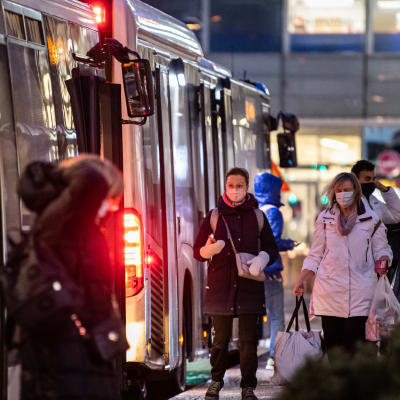 Ihmisiä poistuu ja menee bussiin Espoon Matinkylässä.