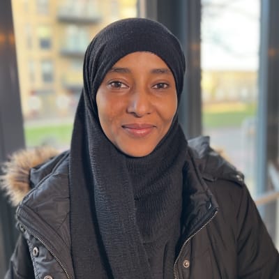 Kvinna i svart hijab tittar rakt in i kameran