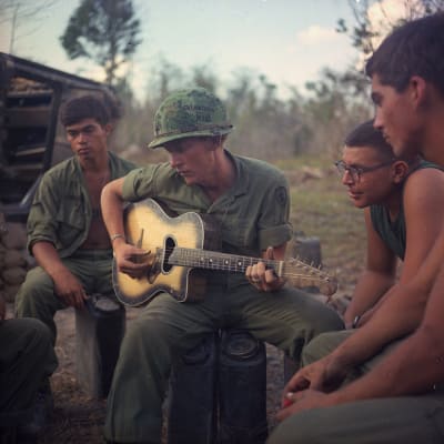 Amerikkalaissotilas soittaa kitaraa tovereilleen Vietnamin sodassa