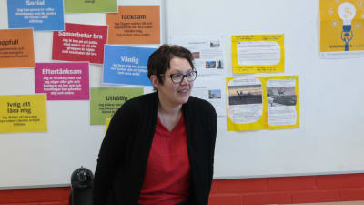 Studiehandledare Maarit Munkki står framför en anslagstavla i ett klassrum