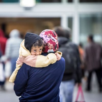 En asylsökande bär på sitt barn.