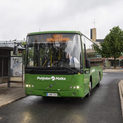 Vihreä linja-auto bussipysäkillä. 