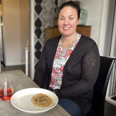 Kimberley Gowdy istumassa edessään hänen leipomansa keksi.