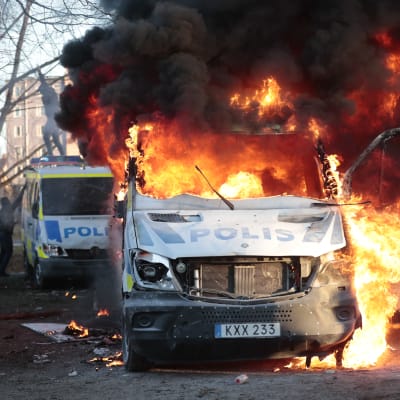 Två polisbilar som brinner.