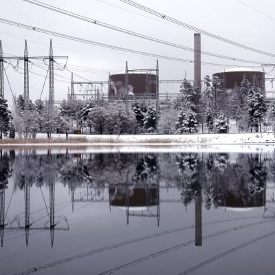 Ett vintrigt landskap med två kärnreaktorer och elledningar
