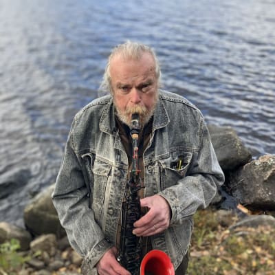 Seppo Laine soittaa saksofoniaan Muratjärven rannalla.