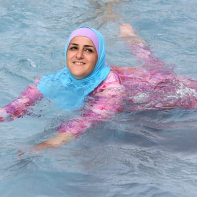 En ung kvinna simmar i burkini i en simbassäng i Berlin år 2012.