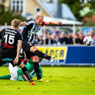 Timi Lahti dunkar iväg bollen, Hindrek Ojamaa och Eero-Matti Auvinen tittar på.
