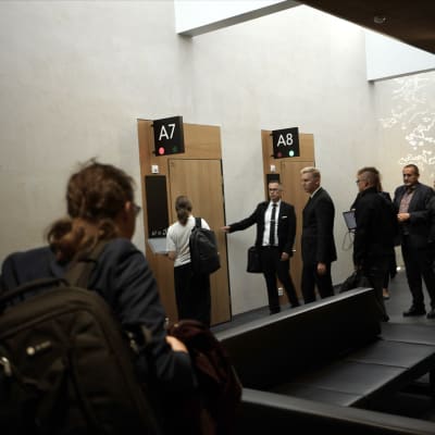 Ihmiset ovat menossa ovesta sisään Oulun käräjäoikeuden saliin.