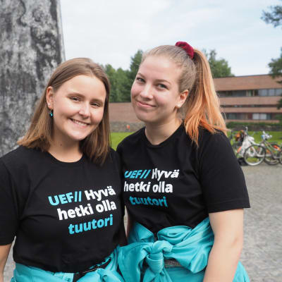 Itä-Suomen yliopiston psykologian opiskelijat Sara Ruokolainen ja Kerttu Lehtonen tuutoriasuissaan yliopiston edustalla Joensuussa.