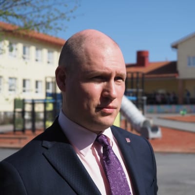 Juuan kunnanjohtaja Henri Tanskanen seisoo Juuan purettavan keltaisen koulun edustalla.