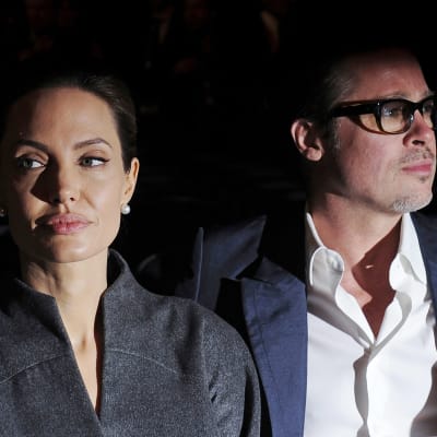 Angelina Jolie katsoo vasemmalle. Vieressä Brad Pitt katsoo oikealle.