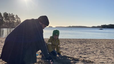Ted leker på stranden med sin son Lo.