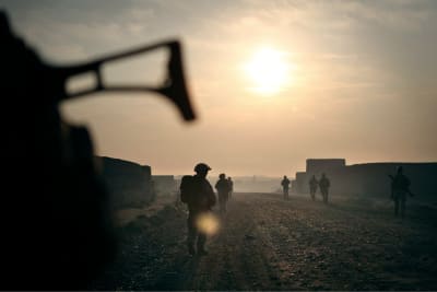 Soldater i solnedgång på en sandväg.