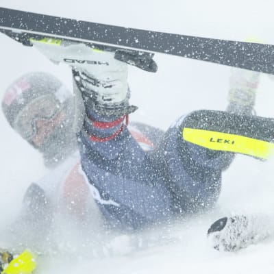 AJ Hurt kaatuu Levin pujottelurinteessä ja lumi pöllyää.