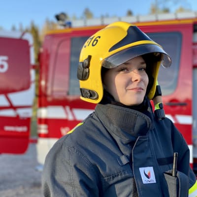 En kvinna i brandmansuniform.