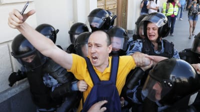 Demonstrant grips av poliser i Moskva. 