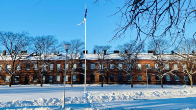 Nylands brigad med flaggan i topp en solig vinterdag med knallblå himmel