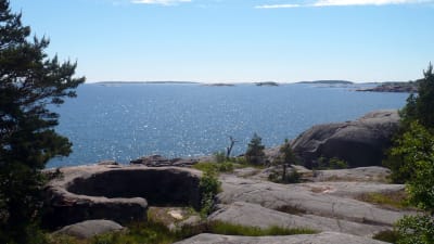 En bergsklippa med utsikt över hav.