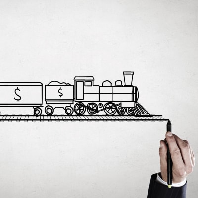 En hand ritar en järnvägsbana och ett ritat tåg ned dollartecken på kör på banan.