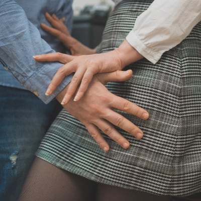 En man lägger händerna på en kvinnas höfter.