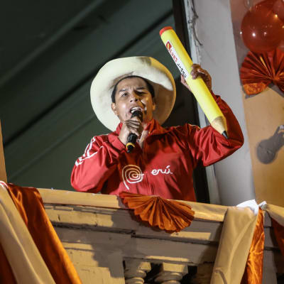 Den peruanske presidentkandidaten Pedro Castello talar till sina anhängare från ett fönster.