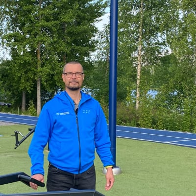 man i blå huvtröja står framför en gym apparat