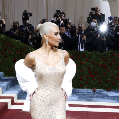 Kim Kardashian  Marilynin tiukassa vaaleassa mekossa salamavalojen välkkeessä.