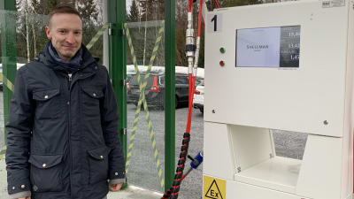 En man står intill ett tankställe för biogas