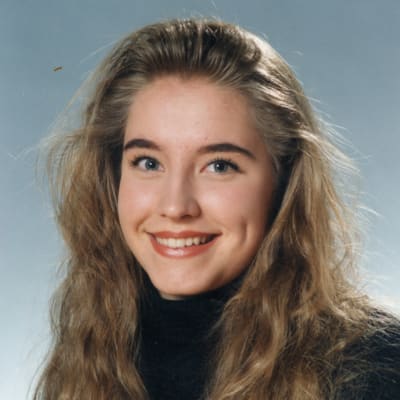 Jenni Pääskysaari poseeraa iloisesti hymyillen lukion koulukuvassa.