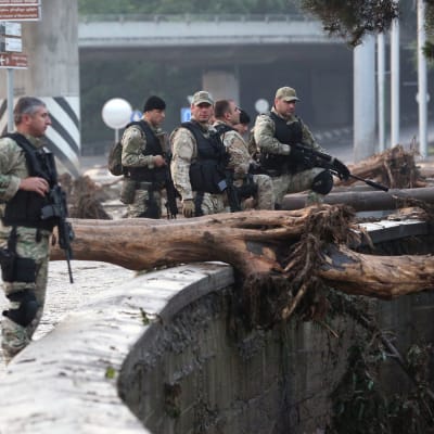 Beväpnad polis partullerar på de översvämmade gatorna i Tbilisi.