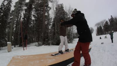 Pojke gör snowboardtricks på en dancefloor ramp