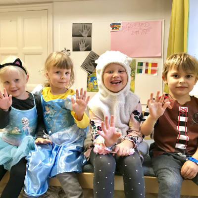 Fyra glada dagisbarn i maskeradkläder.