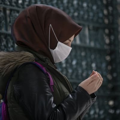 Nainen rukoilee hengityssuojain kasvoillaan moskeijassa Istanbulissa keskiviikkona.
