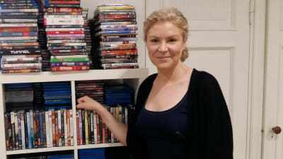Filmproducenten Leila Lyytikäinen poserar vid en dvd-hylla