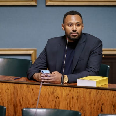 Vasemmistoliiton kansanedustaja Suldaan Said Ahmed istumassa omalla paikallaan eduskunnan istuntosalissa.