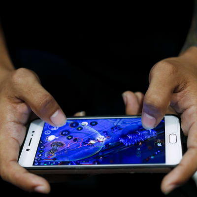 Man som spelar mobilspel.  