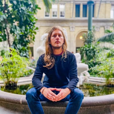 Otto Gabrielsson sitter vid en fontän 