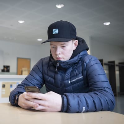 Santeri Salmela kirjoittaa puhelimellaan. 