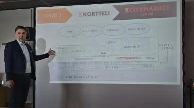Man presenterar byggplaner med bilder från en power point. 