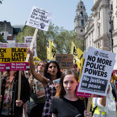 Suuri joukko mielenosoittajia pitelee kylttejä, joissa muun muassa vaaditaan Lontoon poliisin hajottamista.