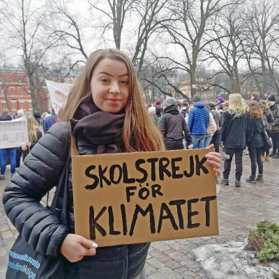Veera Sellgren demonsterar klimatförändringarna med en skylt i händerna.  