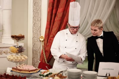 En kock och en servitör som står och diskuterar för maten på slottet.