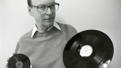 Pekka Gronow kädessään cd-levy ja pikatallenuslevy