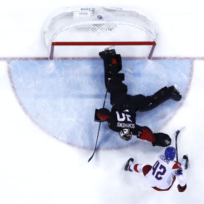 Ishockeymålvakten Ben Scrivens ligger på mage för att få tag i pucken.