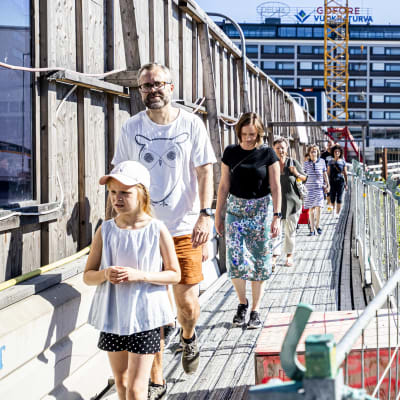 grupp människor som går en rundvandring och tittar på underjordiska parkering som byggs i åbo centrum